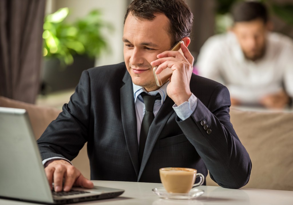 Man at computer on phone