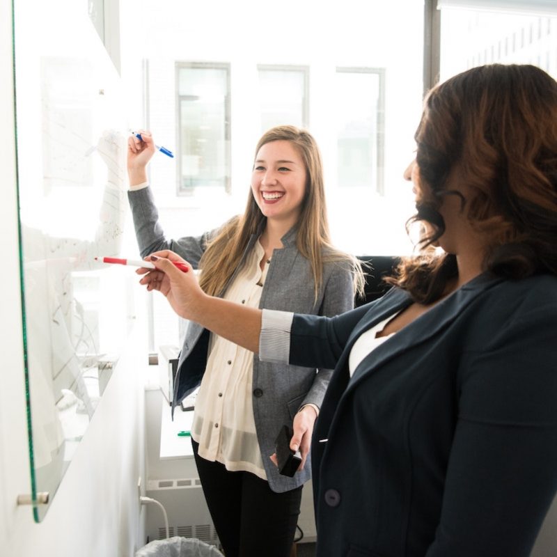 2woman_writing_whiteboard