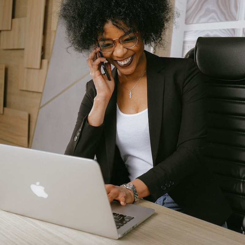 Woman in an office on the phone and laptop